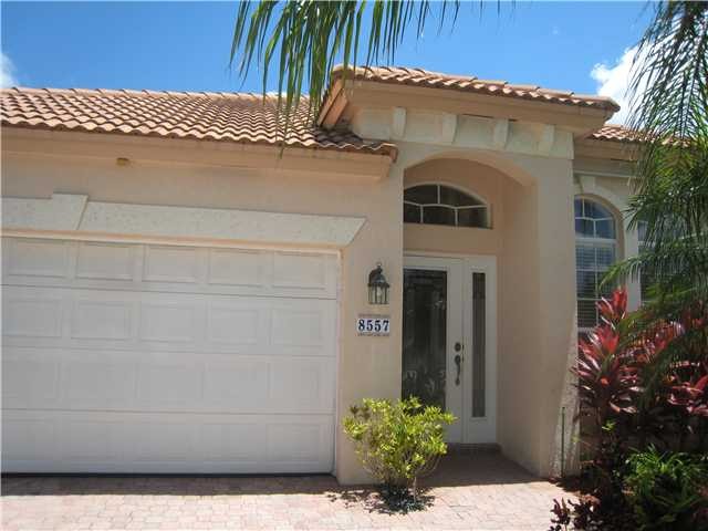 beautiful impact glass entrance door. accordion shutters and decorative drive.