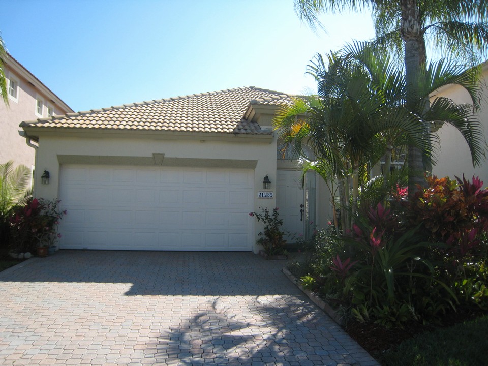 mizner pointe three bedroom with large fenced in back yard. decorative drive and accordion shutters. tile on the diagonal and breakfast bar in kitchen with granite coutners.